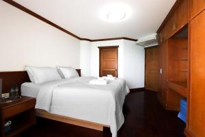 a bedroom with a large white bed and wooden cabinets at Sky beach view in North Pattaya