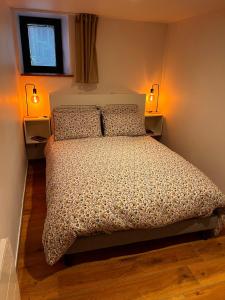 a bedroom with a bed with two lights on it at Gîte de Charme in Saint-Avit-de-Tardes