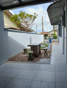a patio with a table and benches in a building at Aplus Homestay Kluang A嘉民宿 in Kluang