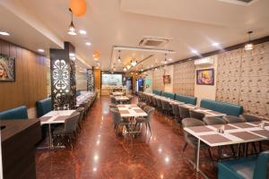 a restaurant with tables and chairs in a room at Hotel Krishnam Vrindavan in Vrindāvan