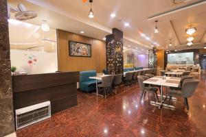 a restaurant with tables and chairs and a bar at Hotel Krishnam Vrindavan in Vrindāvan