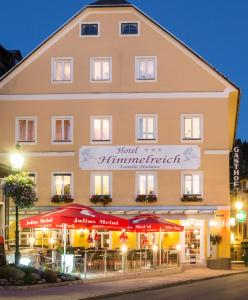 un hotel con mesas y sombrillas frente a un edificio en Hotel Himmelreich, en Mariazell