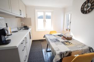 a kitchen with a table with chairs and a window at Gosse House in Deal