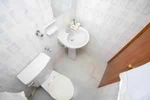 a white bathroom with a toilet and a sink at Hotel Sweet Place in Dhaka +10 photos