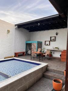 a swimming pool on a patio with a table and chairs at Casa Samuel in Honda