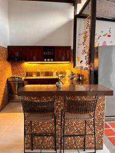 a kitchen with a counter and two chairs at a bar at Casa Samuel in Honda