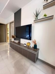a living room with a large tv on the wall at Foavahi Shark View Inn in Fuvahmulah