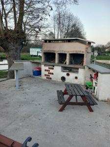 a picnic table and a grill with a picnic table and a bench at Caravane in Beaufay
