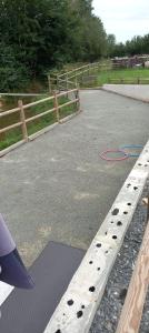 a road with a fence and a red hose on the ground at Caravane in Beaufay
