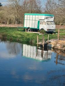 a truck is parked next to a body of water at Caravane in Beaufay