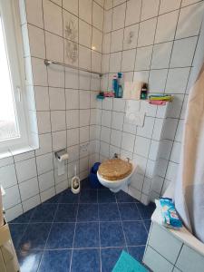 a tiled bathroom with a toilet and a sink at Fair-Hostel in Darmstadt +35 photos
