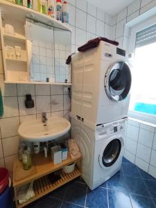 a bathroom with a washing machine and a sink at Fair-Hostel in Darmstadt