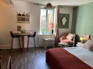 a bedroom with a bed and a table and a chair at La mésAnges in Giverny