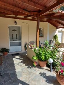 a patio with potted plants and a wooden roof at Kerkis View House-Garden View in Karlovasi