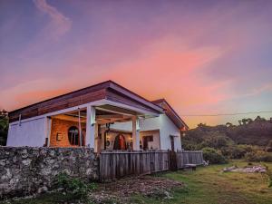 a house with a stone wall in a field at Loti Guest House in Kupang