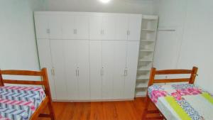 a bedroom with white cabinets and a bed and a shelf at Varandas Av Paulista in São Paulo
