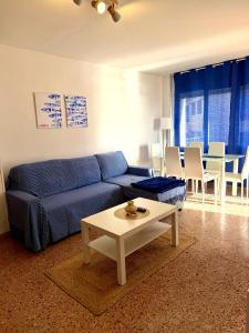 a living room with a blue couch and a table at Ocean Breath Home in L'Ametlla de Mar