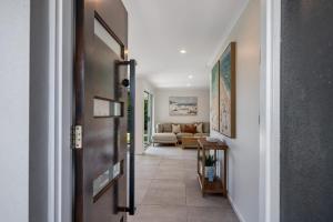 a hallway with a door leading to a living room at Mooloolaba Canal Retreat with Pool Sleeps 12 in Mooloolaba