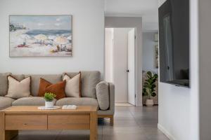 a living room with a couch and a table at Mooloolaba Canal Retreat with Pool Sleeps 12 in Mooloolaba +49 photos