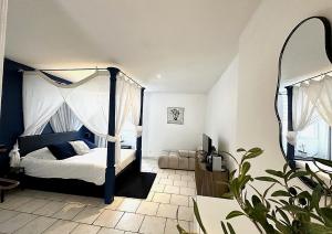 a bedroom with a canopy bed and a mirror at Villa Hyper Centre Le Blanc Type Hotel Entrée Autonome Spa et Nuit en brenne in Le Blanc
