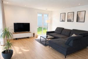 a living room with a couch and a flat screen tv at Moderne Wohnung am Flussufer in Herford