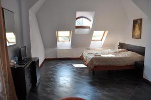 a bedroom with two beds and a tv and windows at Dworek Bogdanka in Trzebin