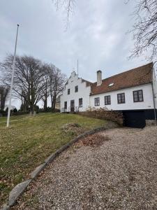 a white house with a garage in front of it at Skelby Præstegård lej 2 in Gedser