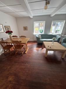 a living room with tables and a couch at Skelby Præstegård lej 2 in Gedser