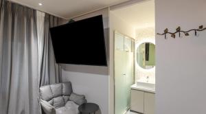a living room with a chair and a television on a wall at 아티초크 호텔 in Kajŏng-dong +71 photos