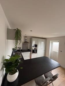 a kitchen with a large black table and chairs at Whistle Stop Terrace in Barnby Dun