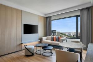 a living room with a couch and a table and chairs at Courtyard By Marriott Tirupati in Tirupati