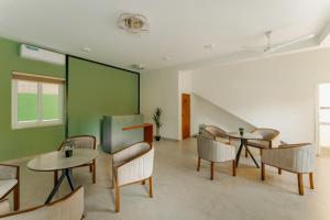 a waiting room with chairs and tables and green walls at Mulberry Living in Negombo