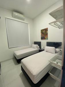 two beds in a room with a large screen at Kampung Febri Resort in Cibuntu