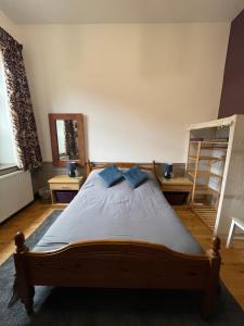 a bedroom with a wooden bed with blue pillows at Beldy Chapel Ground floor apartment in Alston +5 photos