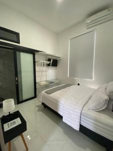 a bedroom with a bed and a large window at Kampung Febri Resort in Cibuntu
