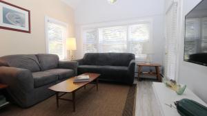 a living room with a couch and a table at Cottage On Cambridge in Cape May Point