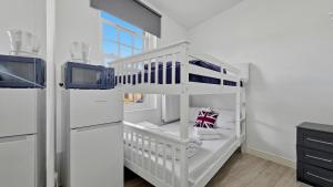 a white baby crib in a kitchen next to a refrigerator at London Duo & Quad Rooms in Zone 2 - Willesden Green in London