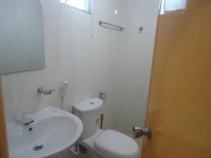 a bathroom with a white toilet and a sink at Blue Moon Rest Inn in Trincomalee