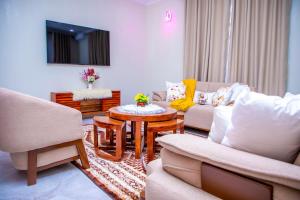 a living room with two couches and a table at Uhondo Apartments in Dodoma