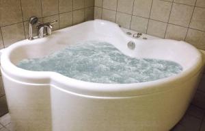 a bath tub filled with water in a bathroom at Konstali Gard in Flekkefjord +40 photos