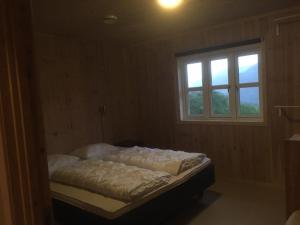 a bed in a room with a window at Konstali Gard in Flekkefjord