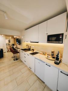 a kitchen with white cabinets and a counter top at Apartman Prime - free parking in Belgrade