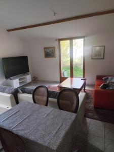 a living room with a couch and a tv at Tableaux in Château-Renault