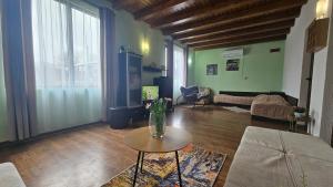 a living room with a vase of flowers on a table at Къща за гости Ореха in Apriltsi