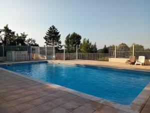 a swimming pool with blue water in a yard at Le Chalet de Pratviel - proche Albi in Puygouzon-et-Montsalvy