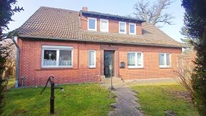 a red brick house with a black door at Fenland Mill Ranch in Wolthausen