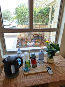 a table with a coffee pot and a window at The Pearl in Sha‘alvim