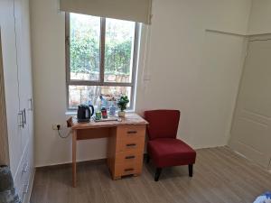a room with a desk and a chair and a window at The Pearl in Sha‘alvim +5 photos