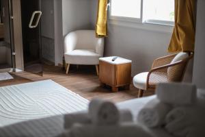 a room with a bed and a chair and a window at Erawan Boutique Hôtel in Évreux