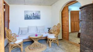 a room with a bed with chairs and a table at Villa Razambe in Mandriankeniheny +24 photos